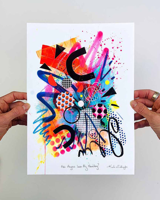 The artist Kate Elkington's hands holding a vibrant, colourful abstract artwork, featuring bold, graphic shapes, dynamic brushstrokes, and playful patterns. The composition includes splashes of neon pink, orange, bright red, and blue, layered with geometric elements such as dots, grids, and curved black lines, radiating energy and movement.