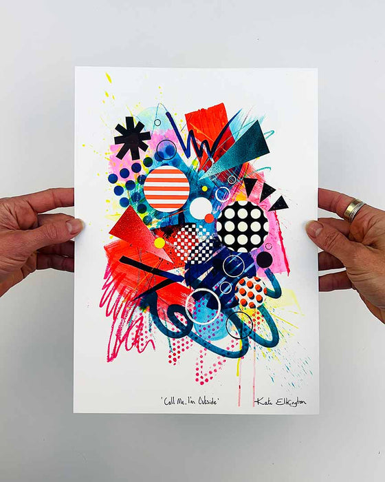 The artist Kate Elkington's hands holding an A4 sized, vibrant, colourful abstract artwork, featuring bold, graphic shapes, dynamic brushstrokes, and playful patterns. The composition includes splashes of neon pink, orange, bright red, and blue, layered with geometric elements such as dots, grids, and curved black lines, radiating energy and movement.