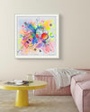 A room featuring a yellow coffee table, pink sofa and a framed colourful, abstract, one-of-a-kind, original, hand-finished, personalised, fine-art print, known as a Personalised-Pimped-Up-Prints by artist Kate Elkington. Neon colours, smileys, geometric shapes, gold letters, expressive textures.Unique and affordable.
